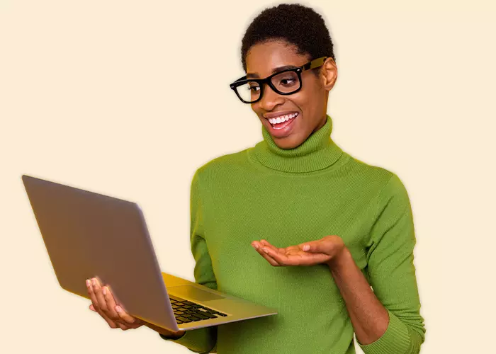 Silmälasipäinen nainen pitelemässä kannettavaa tietokonetta