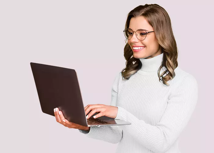 Smiling woman with glasses holding a laptop