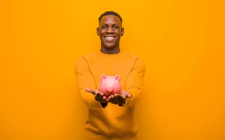 Young man holding a piggy bank