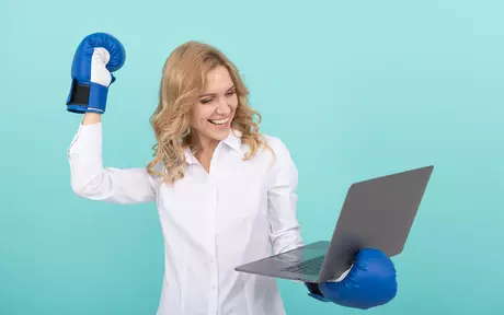 Woman with boxing gloves holding a computer