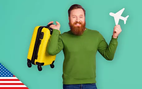 Photo of a man holding a model aeroplane in one hand a suitcase in the other