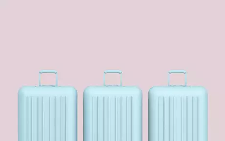 Three blue suitcases on a pink background