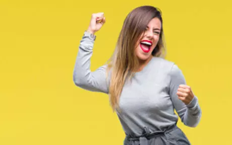 woman dancing and smiling in yellow background