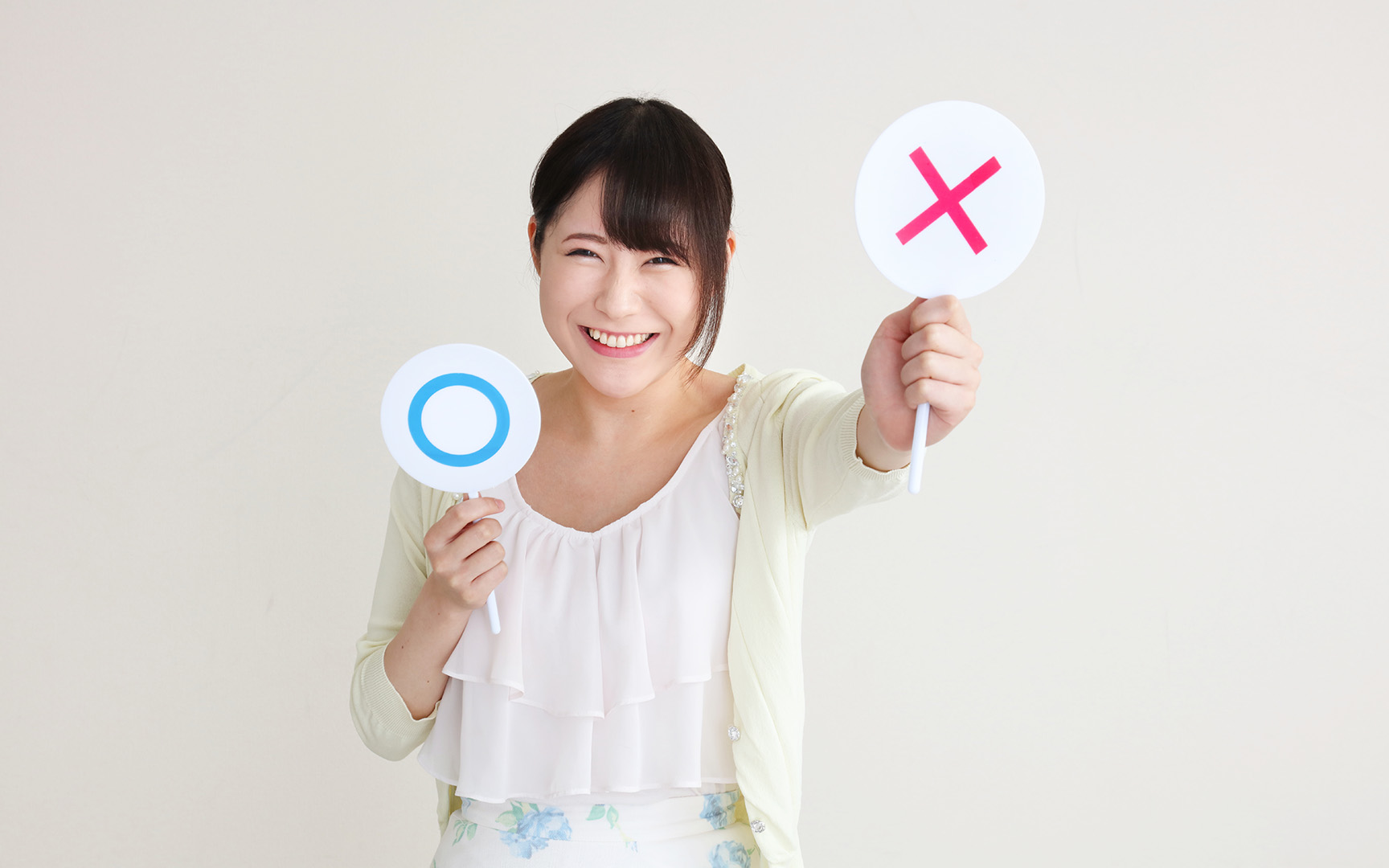 woman holding two signs with letters x and o