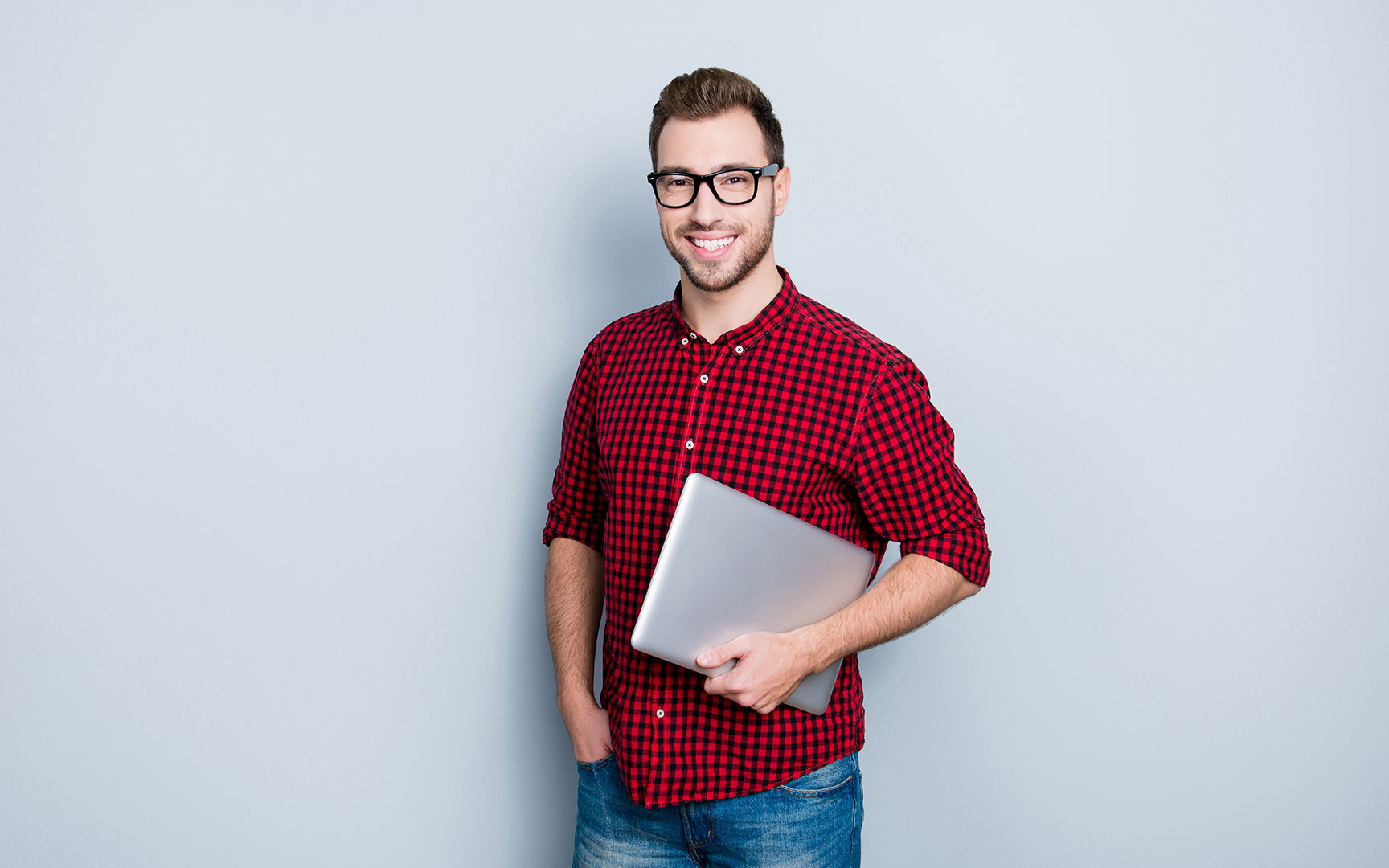 Man in red shirt holding a computer