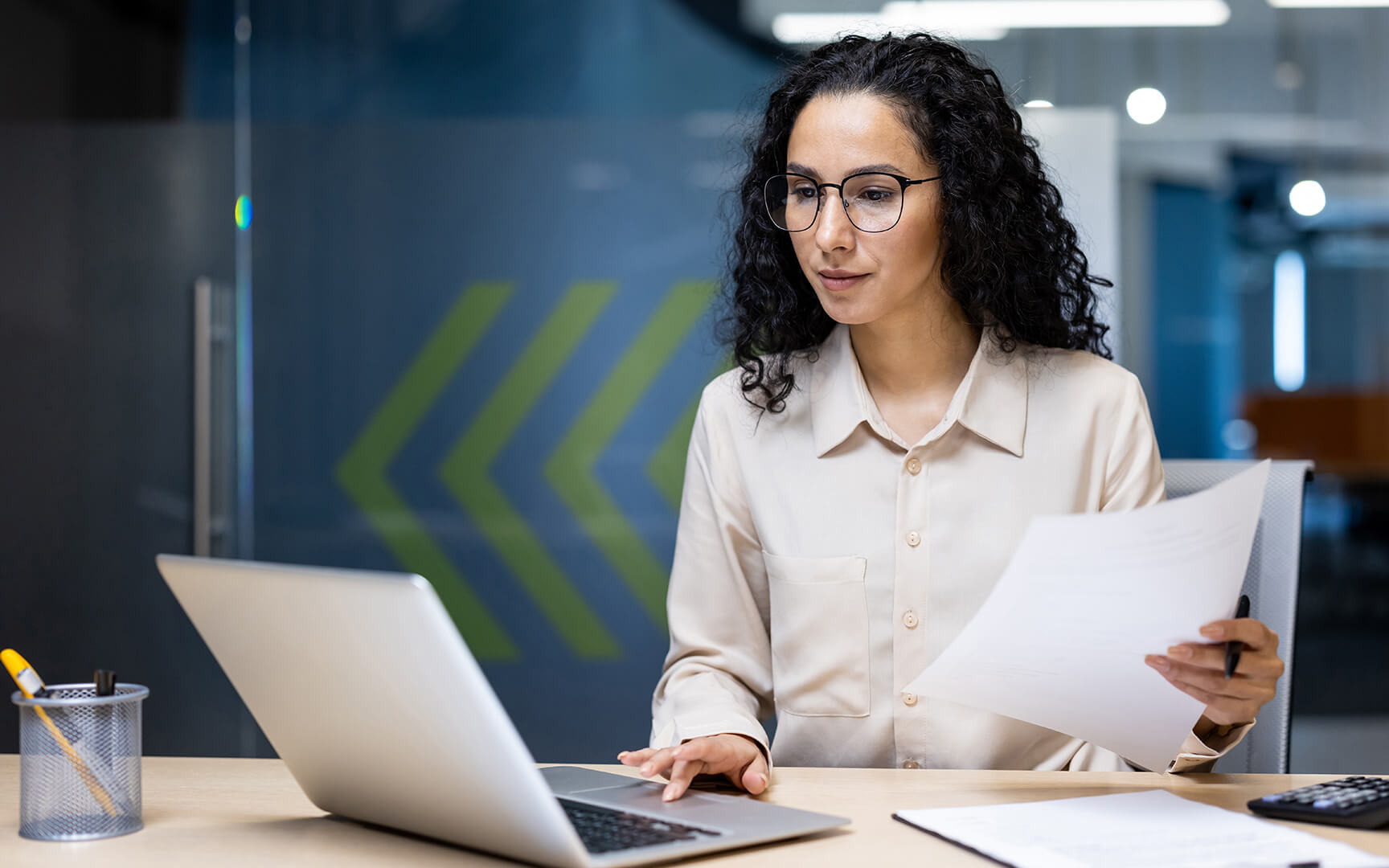woman sited at a table looking at a laptop