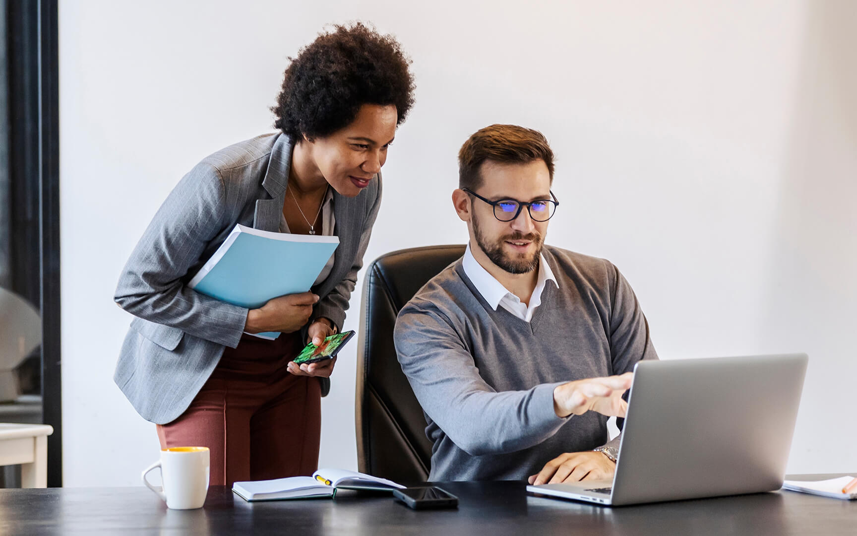 couple talking while pointing to a laptop