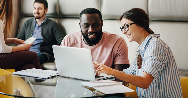 Four individuals in a modern, casual office setting.