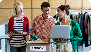 three people gather around a box labeled "donations"