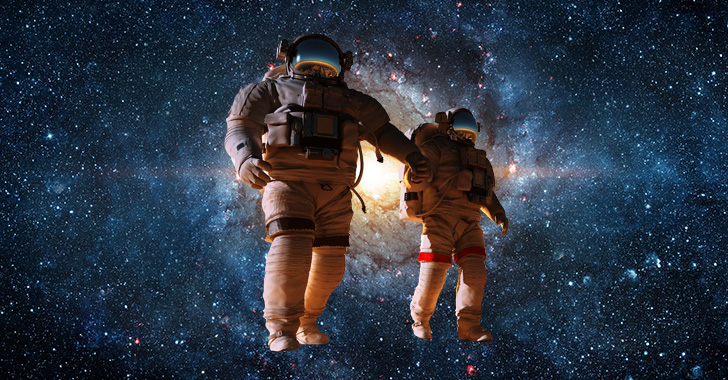 Two astronauts, one larger and one smaller, hold hands while floating in the vastness of space. 
