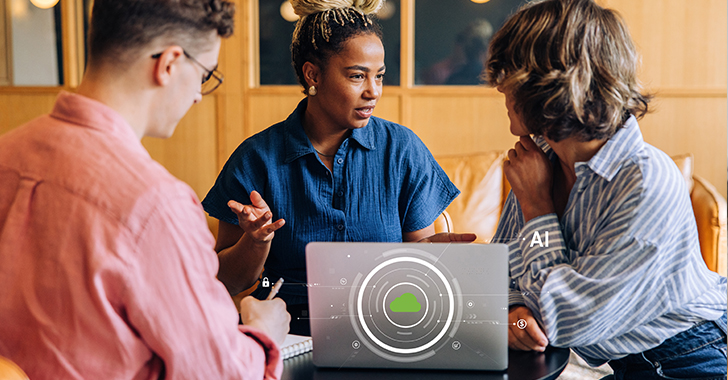 Three colleagues collaborate around a laptop in a warm, modern workspace.