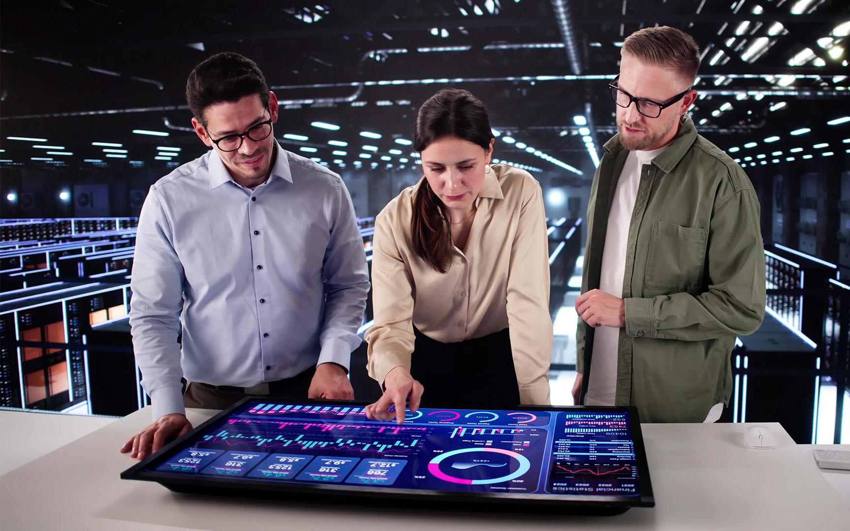 Three professionals collaborate around a large interactive touchscreen displaying procurement and business analytics dashboards with charts, graphs, and performance metrics.