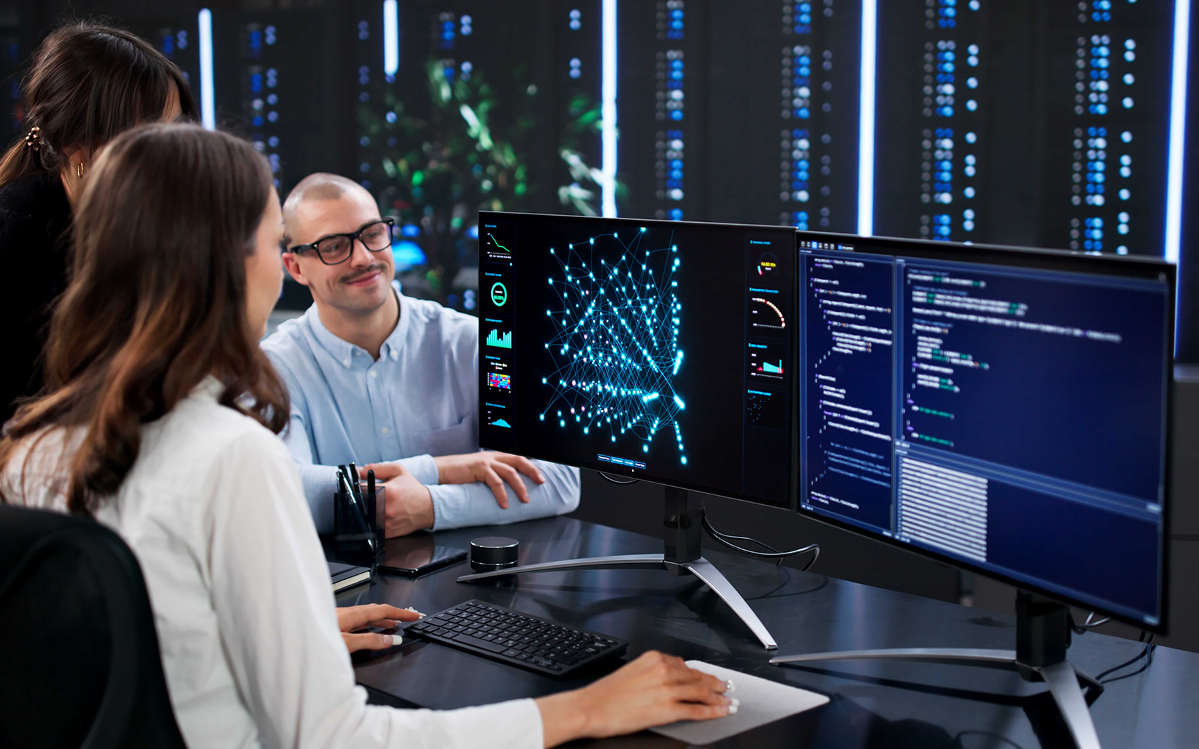 Team members reviewing AI analytics and data visualizations on multiple computer screens in a modern office.