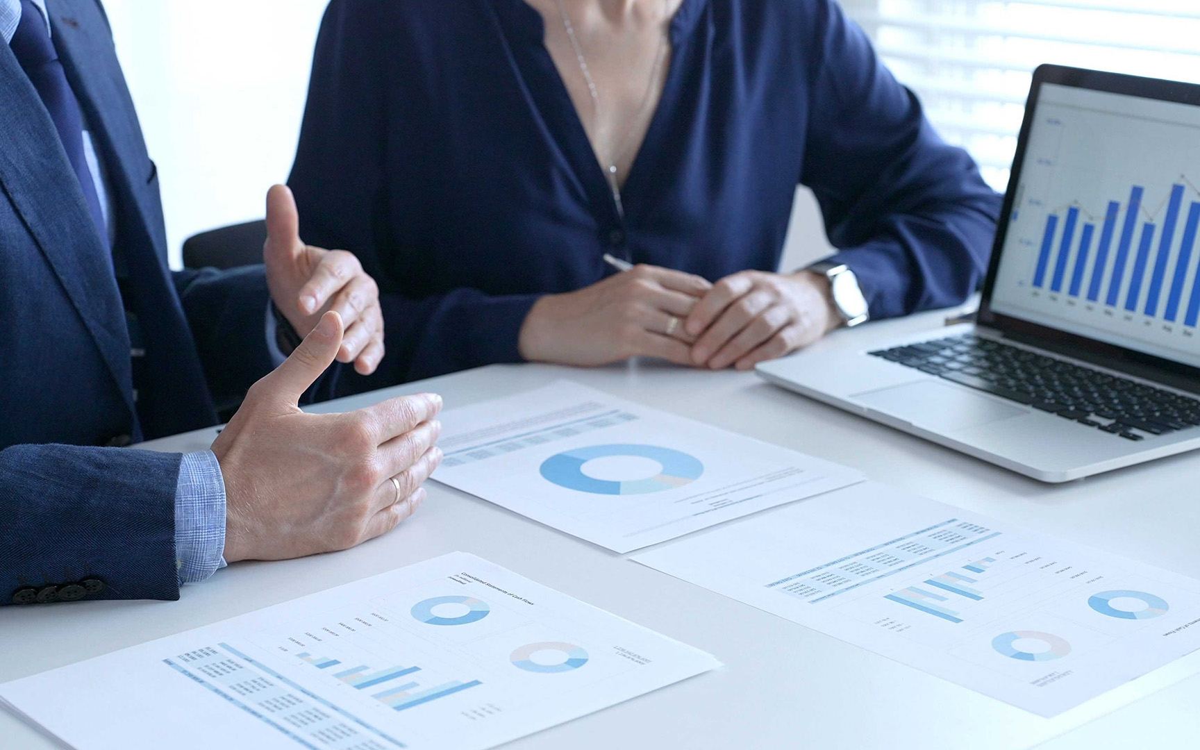 Business professionals reviewing financial reports and performance metrics during a meeting.