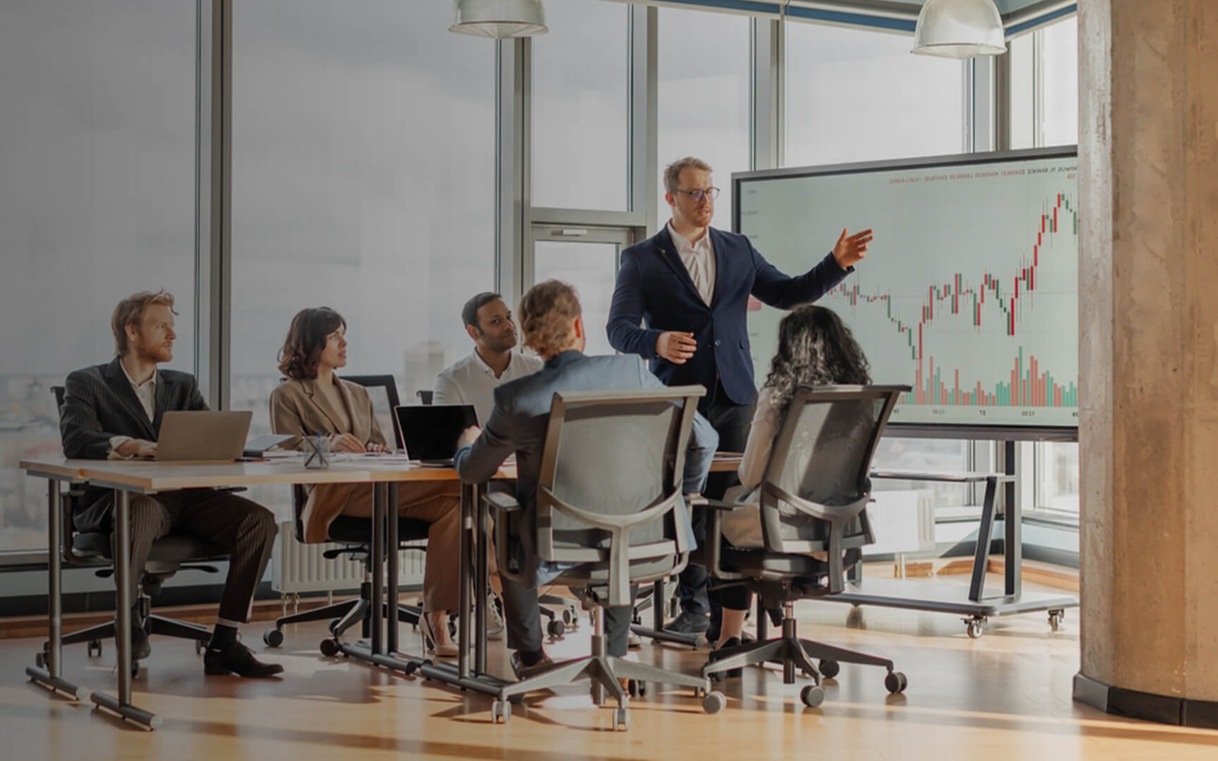Business professionals gathered in a meeting room while a presenter discusses financial performance data displayed on a large screen, illustrating strategic planning, AI-driven finance insights, and decision-making.