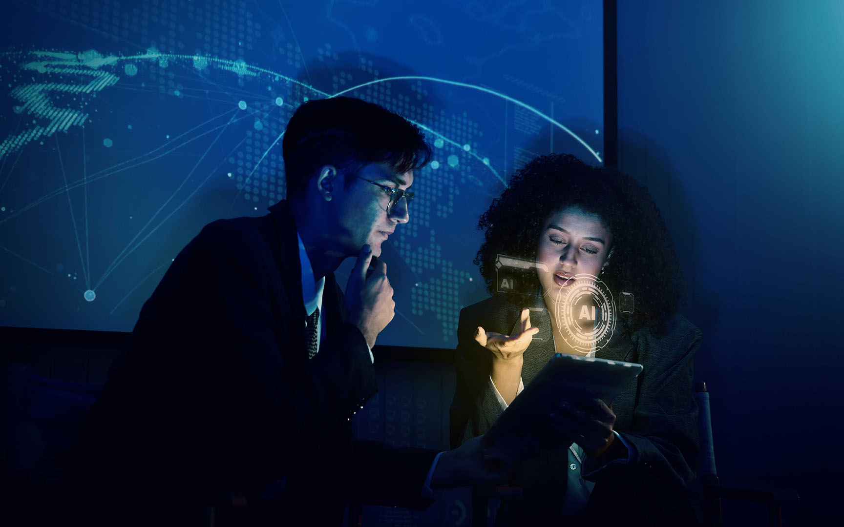 Two professionals review information on a tablet in a dimly lit office, with AI interface graphics and a global digital network displayed in the background, illustrating explainable AI and data-driven decision-making in finance.