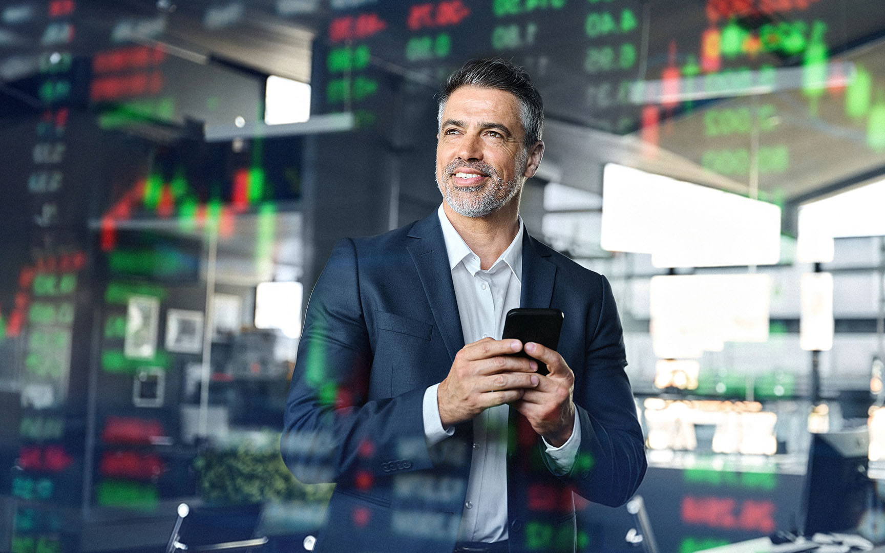 Professional standing in a modern office environment holding a smartphone, with transparent financial market data, stock charts, and trading figures overlaid across the image, illustrating data-driven decision-making, financial analysis, and business intelligence.