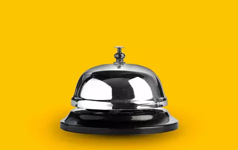 Image of reception bell on yellow background