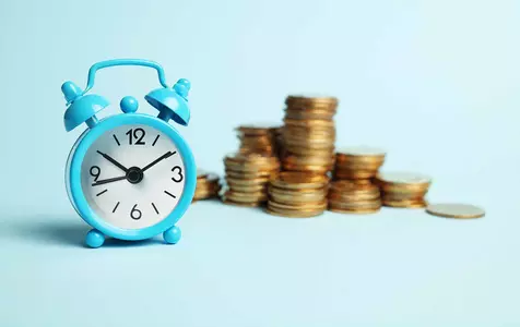 Image showing an alarm clock and stacks of coins