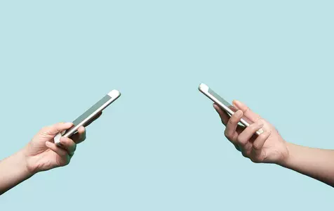 image of two people's hands holding a mobile phone