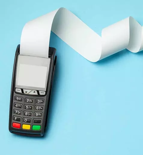 A calculator with a paper printout curling out of the top and out of sight