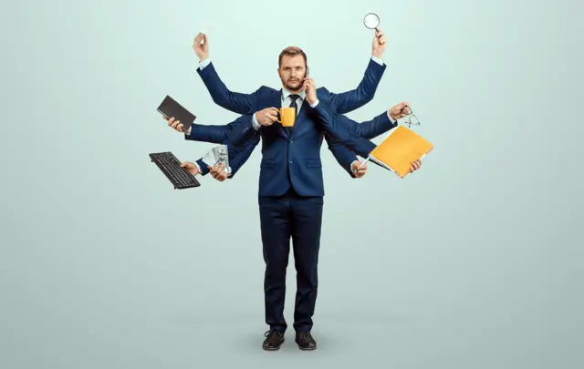 man in suit with 10 arms, holding mug, phone, money, lightbulb, magnifying glass, keyboard, notebook, glasses pen, folder