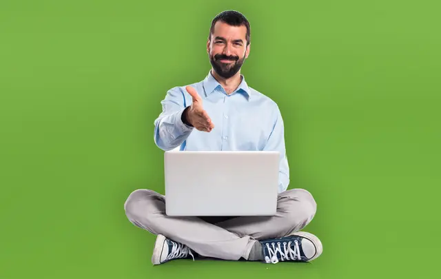 man with laptop sitting cross legged holding up 4 fingers