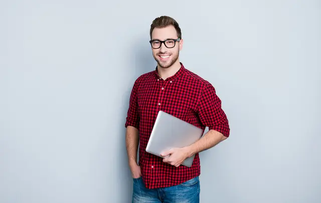 Man in red shirt holding a computer