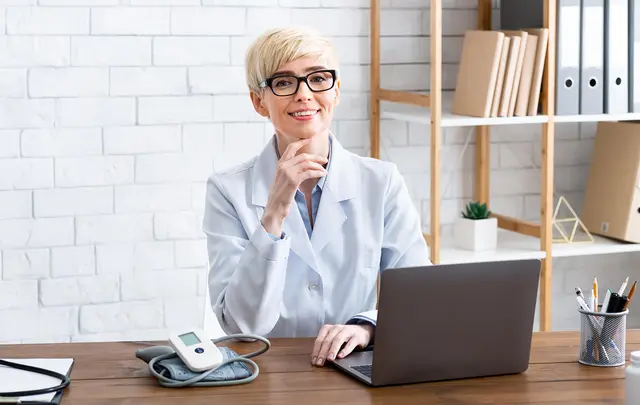 woman smiling with a laptop in front of her