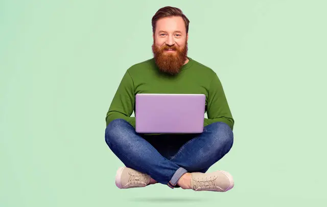 men with a laptop flying and smiling