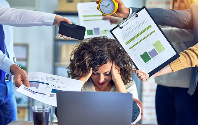 woman in front of a computer with her hands in her head