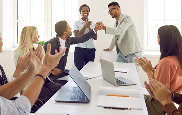 Eight individuals in a bright, modern office setting. 