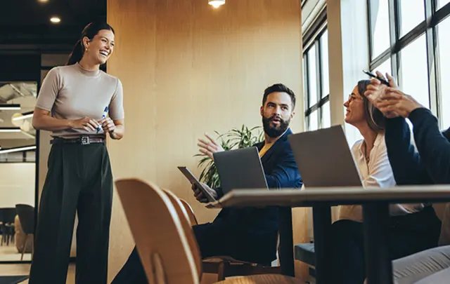Four professionals in a modern office setting engaged in a collaborative session.