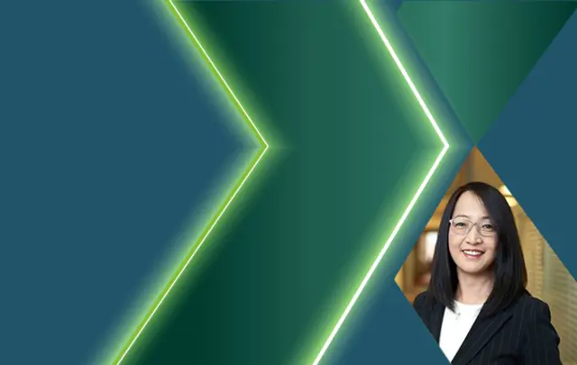 Portrait of an East Asian woman with shoulder-length black hair and glasses, wearing a dark pinstriped blazer over a white top.