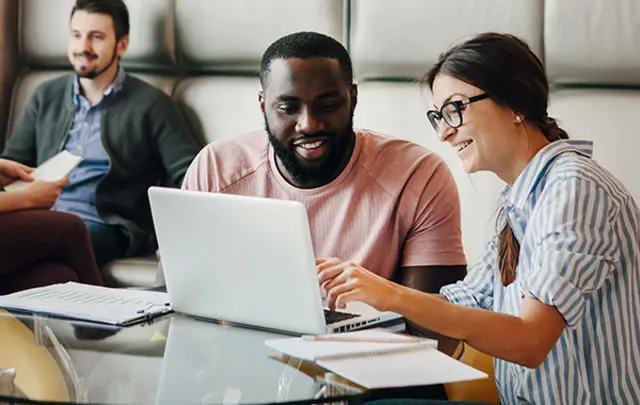 Four individuals in a modern, casual office setting.