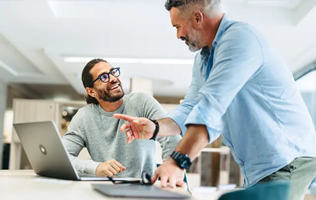 Two men collaborate in a modern office setting. 