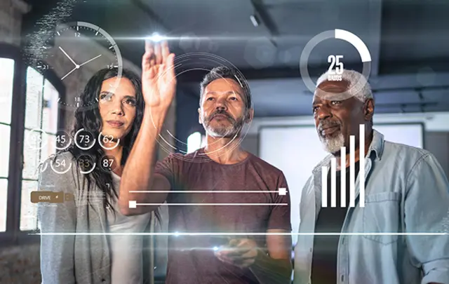 Three professionals in a modern office setting interact with glowing holographic data displays.