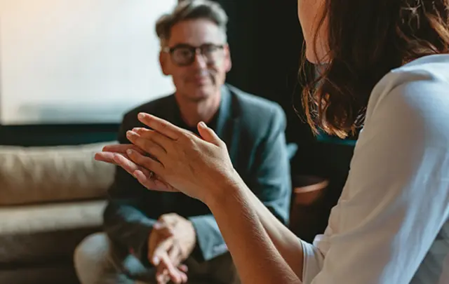 Close-up of a conversation in a softly lit room. 