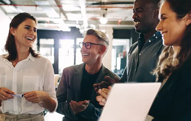 Four diverse professionals collaborate in a bright, modern office.