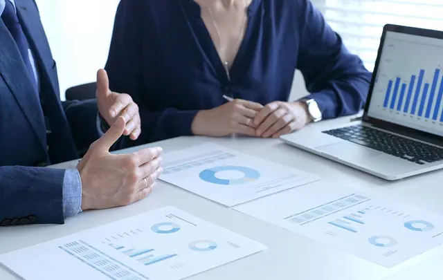 Business professionals reviewing financial reports and performance metrics during a meeting.
