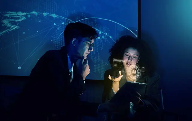 Two professionals review information on a tablet in a dimly lit office, with AI interface graphics and a global digital network displayed in the background, illustrating explainable AI and data-driven decision-making in finance.