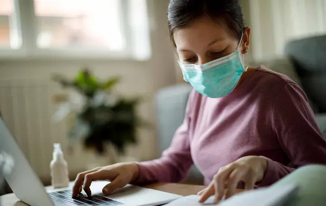 woman behind desk with mask