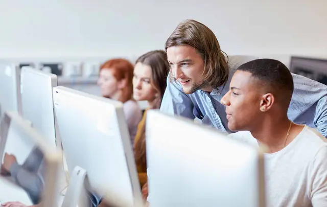 a tutor and student looking at a pc monitor