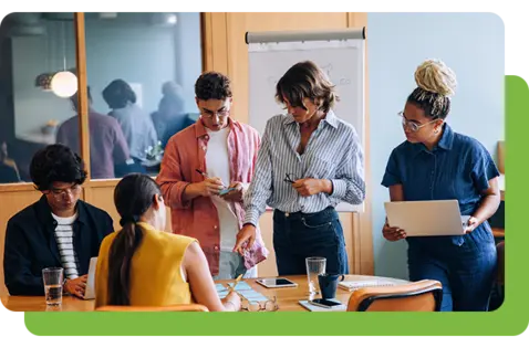 Five individuals gathered around a wooden table in a modern office setting.