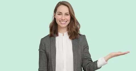 Hymyilevä nainen vaaleanvihreällä taustalla