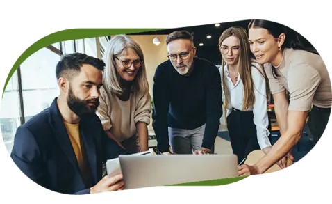 Five professionals gathered around a laptop in a modern office setting.