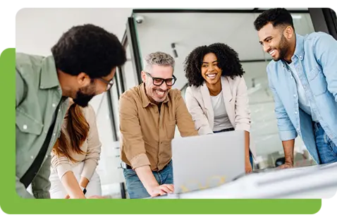 Five professionals gather around a silver laptop on a white table in a modern, well-lit office.