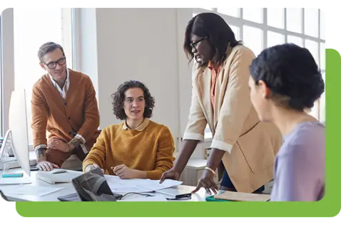 Ein vielfältiges Team von Fachleuten arbeitet gemeinsam in einem hellen Büro an einem Schreibtisch, prüft Dokumente und diskutiert Ideen während einer Arbeitssitzung.
