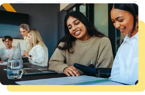A group of professionals reviewing documents and discussing information during a collaborative meeting in a modern office.