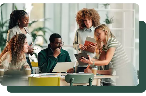 A diverse group of professionals collaborating around a table in a modern office, reviewing documents, a laptop, and a smartphone, with notebooks and coffee cups visible, illustrating teamwork, data analysis, and business decision-making.